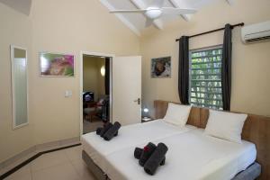 a bedroom with a white bed with two pillows on it at Caracara D1 Relax & Dive Resort Bonaire Village in Kralendijk