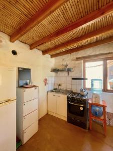 uma pequena cozinha com um fogão e um frigorífico em Casa Adobe - tranquilidad en el Desierto de Atacama em San Pedro de Atacama