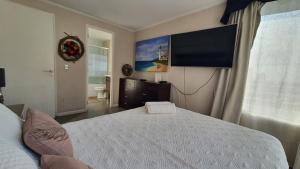 a bedroom with a bed and a flat screen tv at Edificio One in Iquique