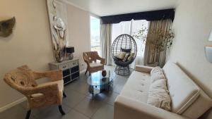 a living room with a white couch and chairs at Edificio One in Iquique