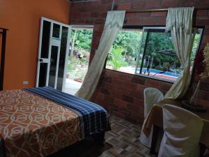 um quarto com uma cama e uma grande janela em Cabañas Horeb em Tena
