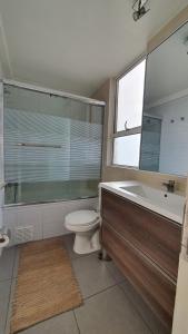 a bathroom with a toilet and a tub and a sink at Edificio One in Iquique