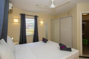 een slaapkamer met een wit bed en een spiegel bij Caracara M4 Relax & Dive Resort Bonaire Village in Kralendijk