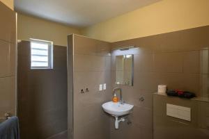 een badkamer met een wastafel en een douche bij Caracara M4 Relax & Dive Resort Bonaire Village in Kralendijk
