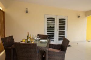 une salle à manger avec une table avec des bouteilles de vin et des chaises dans l'établissement Caracara J4 Relax & Dive Resort Bonaire Village, à Kralendijk