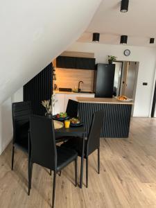 a kitchen and dining room with a table and chairs at Apartamenty Astor - Słoneczny in Szczawno-Zdrój +10 photos