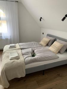 un grande letto con lenzuola e cuscini bianchi di Apartamenty Astor - Słoneczny a Szczawno-Zdrój