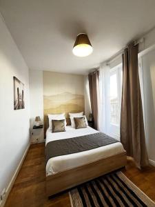 um quarto com uma cama grande e uma janela em 2p : Vue sur les toits de Paris em Les Lilas