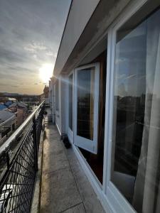 un balcón de un edificio con la puesta de sol en el fondo en 2p : Vue sur les toits de Paris, en Les Lilas