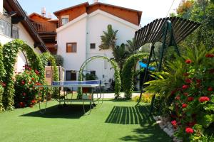 a garden with a table and a bench and flowers at Suites & Spa Galilee in Qiryat Shemona