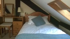 a bedroom with a bed with a wooden headboard and a mirror at Swifts Barn Stanbury Wharf in Holsworthy