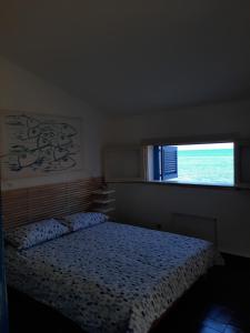 Schlafzimmer mit einem Bett vor einem Fenster in der Unterkunft Appartamento In Villa Al Mare - Baia di Arcile in Brucoli
