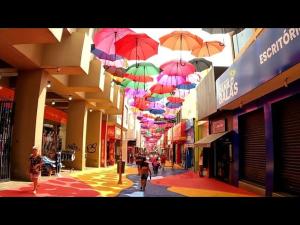 a street with many umbrellas hanging from the ceiling at Km quartos individuais in Sorocaba