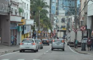 a busy city street filled with cars and buildings at Km quartos individuais in Sorocaba