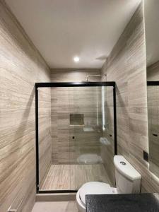 a bathroom with a toilet and a glass shower at Casa Valentina Habitación 3 in Aguascalientes