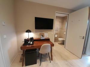 Zimmer mit einem Schreibtisch und einem TV an der Wand in der Unterkunft Hello Zeeland - Appartement Duinenburg 10-2 & 3 in Domburg