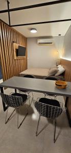 uma mesa e duas cadeiras num quarto com uma cama em Loft aconchegante na melhor localização de BH em Belo Horizonte