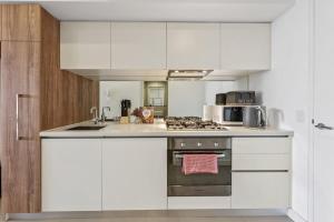 a kitchen with white cabinets and a stove top oven at MA-a 1118 in Melbourne