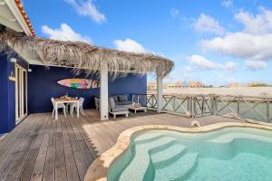 a resort with a swimming pool and a patio with a table at Kas Linde with private pool on the Laguna Marina in Kralendijk