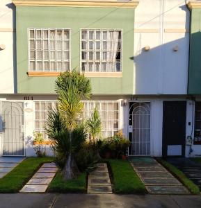 une maison verte avec un palmier en face dans l'établissement Llegaste a casa almendros, à Santa Cruz Tecamac