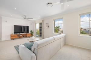 a living room with a couch and a tv at Pool Sauna Cinema Office Room 4BR Spacious house in Gold Coast
