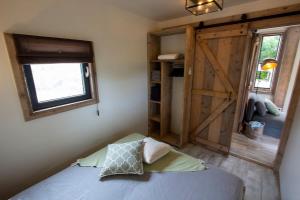 a bedroom with a bed and a sliding barn door at Kas Palulu II a Lovely Tiny House with Jacuzzi in Kralendijk