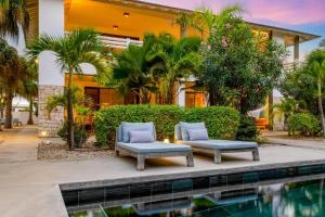 ein Haus mit zwei Stühlen und einem Pool in der Unterkunft Kas Flamingo with Private Pool in Punt Vierkant in Kralendijk