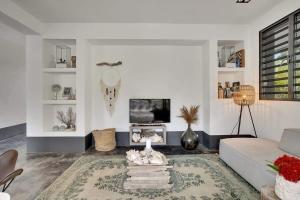 ein Wohnzimmer mit Sofa und Fernseher in der Unterkunft Kas Flamingo with Private Pool in Punt Vierkant in Kralendijk