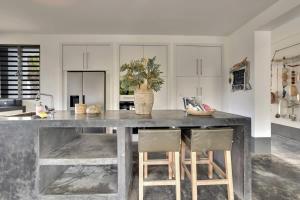 eine Küche mit einem großen Tisch mit zwei Stühlen in der Unterkunft Kas Flamingo with Private Pool in Punt Vierkant in Kralendijk + 45 Fotos