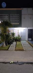 a white building with a palm tree in front of it at Llegaste a casa almendros in Santa Cruz Tecamac