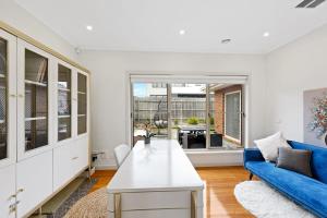 a living room with a blue couch and a table at 3BR Townhouse 7km to Chadstone in Chadstone