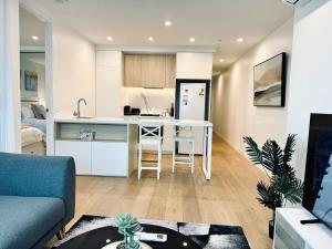 a kitchen and living room with a table and a couch at Chic 1BR Apt Urban Retreat Pool Parking Gym in Box Hill