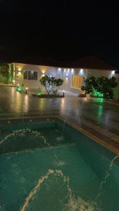 una casa con piscina di notte di شاليه النجمه الذهبيه a Al Harazat