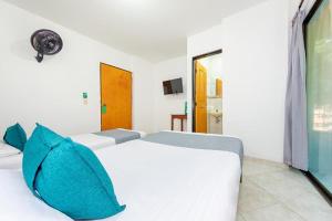 a bedroom with two beds with blue pillows at Hotel Balcones 70 Laureles in Medellín