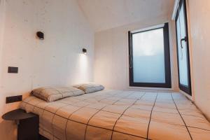 a bedroom with a large bed with a large window at Hello Zeeland - Vakantiehuis Kerkstraat 1A in Domburg