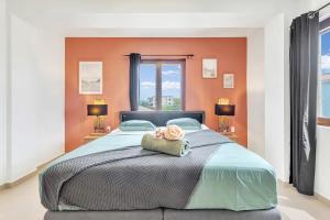 una camera da letto con un grande letto con pareti arancioni di Chachacha Beach Condo a Kralendijk