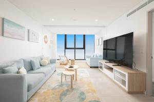 a living room with a couch and a tv at Just a stone's throw to the Beach Brand new 2BR in Gold Coast