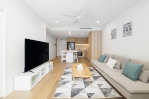 ein Wohnzimmer mit einem Sofa und einem Flachbild-TV in der Unterkunft B-A Altura 81003 in Brisbane