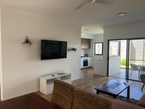 uma sala de estar com um sofá e uma televisão na parede em Stunning 3BR in Serene Loc Varied Amenities BBQ em Gold Coast