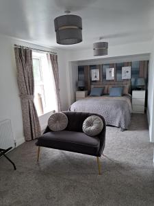 um quarto com uma cama e um sofá de couro preto em Old Sun Hotel em Haworth