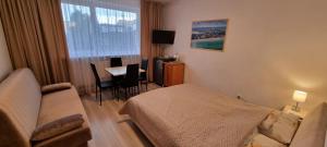 a hotel room with a bed and a couch and a table at Pogodna 3B in Mielno