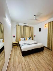 a bedroom with two beds and a wooden floor at Melvet Residency in Cochin +29 photos