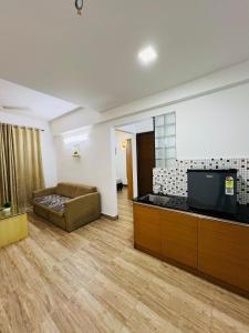 a living room with a couch and a flat screen tv at Melvet Residency in Ernakulam