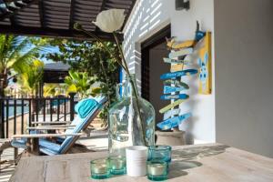 Eine Vase mit einer Blume auf dem Tisch. in der Unterkunft Villa de Agua 7 in Waterlands Village in Kralendijk