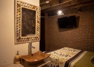 La salle de bains est pourvue d'un lavabo, d'un miroir et d'un lit. dans l'établissement Hotel Villas Mariposas, à Atlixco