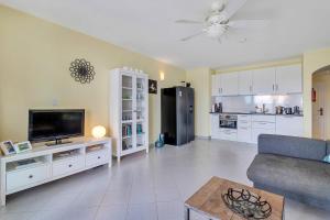 uma sala de estar com um sofá, uma televisão e uma cozinha em Port Bonaire Oasis A701 with Sea View em Kralendijk