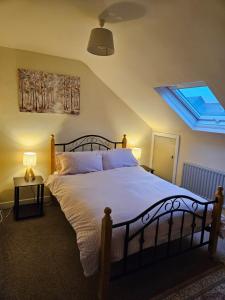 a bedroom with a large bed with a skylight at Main Street Swinford! in Swinford