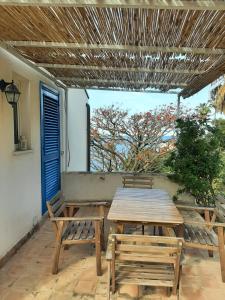 een houten tafel en stoelen op een patio bij Appartamento In Villa Al Mare - Baia di Arcile in Brucoli
