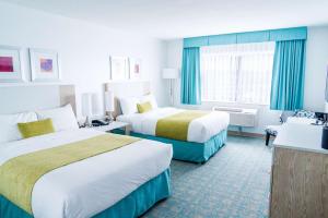 a hotel room with two beds and a couch at Coast Hotel & Convention Centre in Langley +32 photos