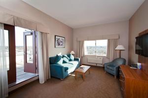 a living room with a blue couch and a television at Coast Hotel & Convention Centre in Langley